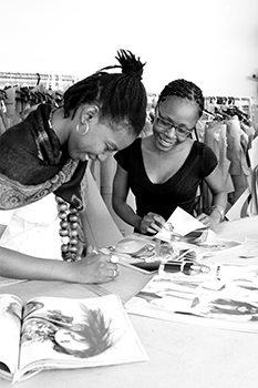 Greyscale workers leaning over a design book