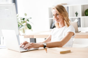Confident businesswoman working on laptop