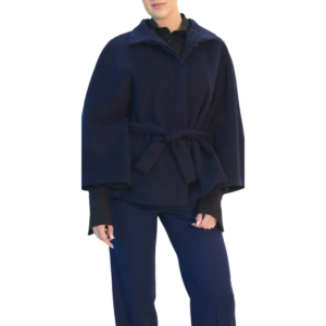 Standing person wearing a dark blue cape jacket with a tied belt, black shirt, and dark blue trousers.