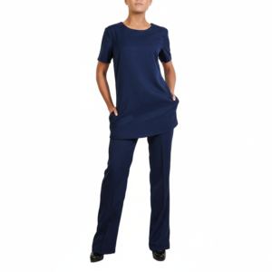Professional in comfortable navy blue short-sleeved tunic and matching trousers, hands in pockets.