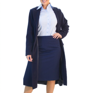 Person in a light blue shirt, navy skirt, and open navy coat, standing with left hand on hip.