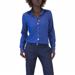 Blue long-sleeve button-up shirt with white buttons, dark blue trousers on a standing person with hands in pockets.