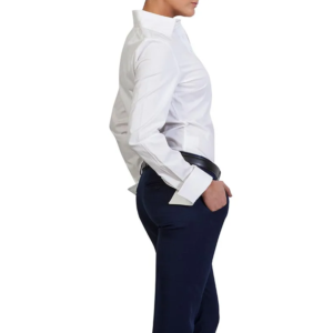 Profile of person in crisp white French cuff shirt, tailored navy trousers, black belt, one hand in pocket.