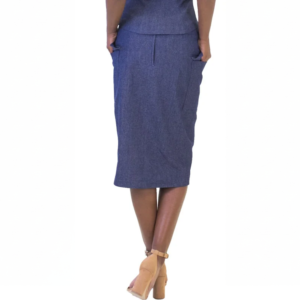 Rear view of a person in a blue pencil skirt, hands in pockets, with tan block heels. Modern business fashion.