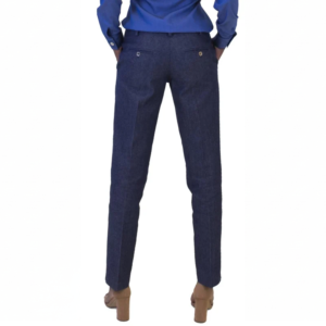 Back view of a person in a casual blue shirt, dark blue pants with back pockets, and tan block-heeled sandals.