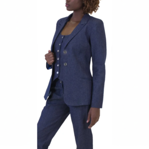 Person in a dark blue denim-look three-piece suit, standing, adjusting blazer lapel.