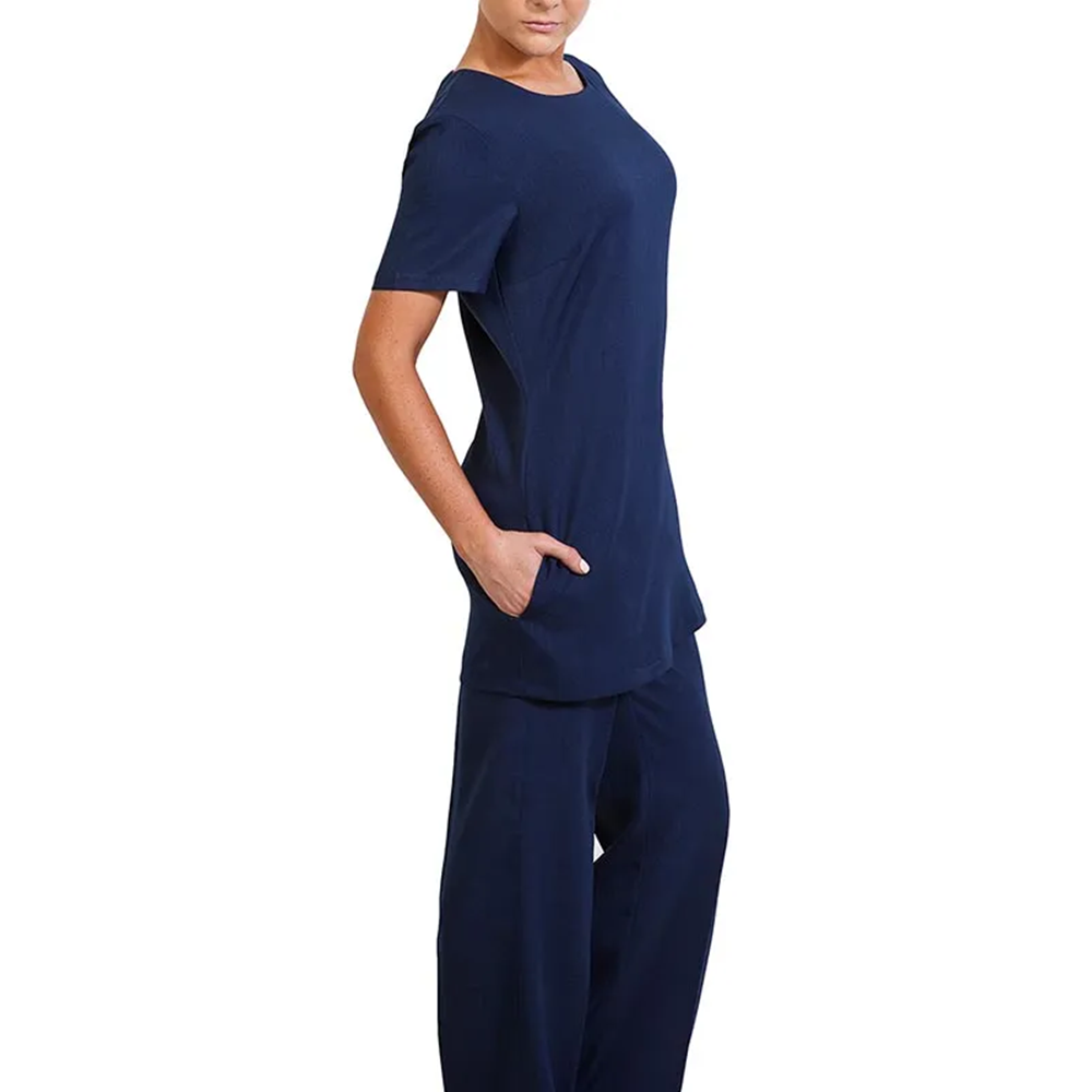 Person in navy short-sleeve tunic and wide-leg pants, standing in profile with hand in pocket. Effortless casual fashion.