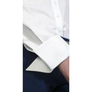 Crisp white men's dress shirt with double-fold cuffs and white buttons, styled with dark trousers.