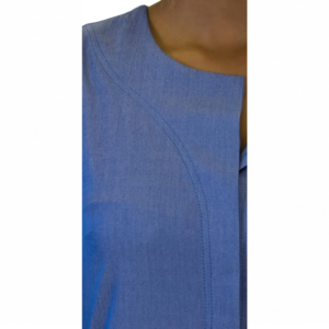 Close-up of a blue crewneck top, featuring curved stitching details across the upper chest.