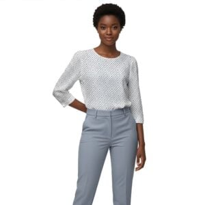 Elegant women’s fashion outfit featuring a geometric print blouse and tailored grey trousers, perfect for professional or smart-casual settings. Stylish, modern clothing from Karma Clothing 2.0.
